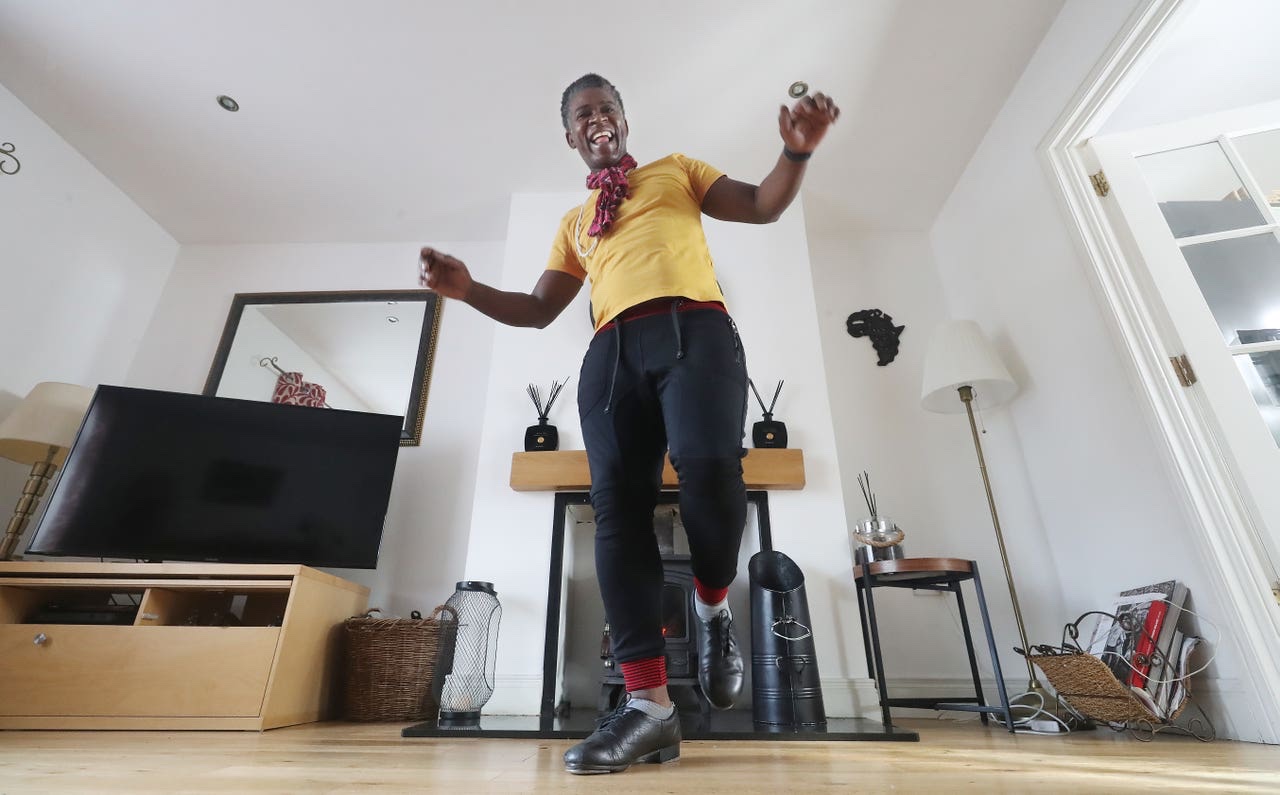 Tura Arutura tap dancing in his living room in front of a fireplace